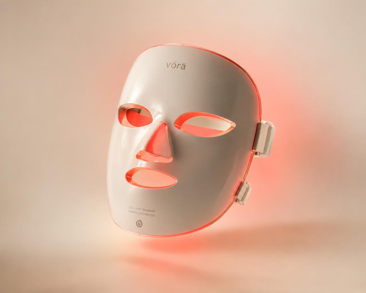 Omnilux LED light therapy face mask glowing with warm red light